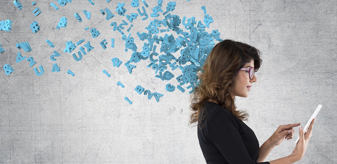 Digital letters and numbers supposedly flying from a woman's head as she works on a tablet