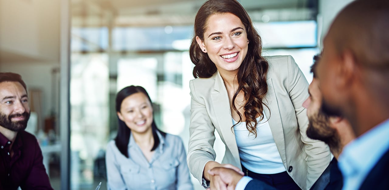 Young business woman greeting people in a meeting